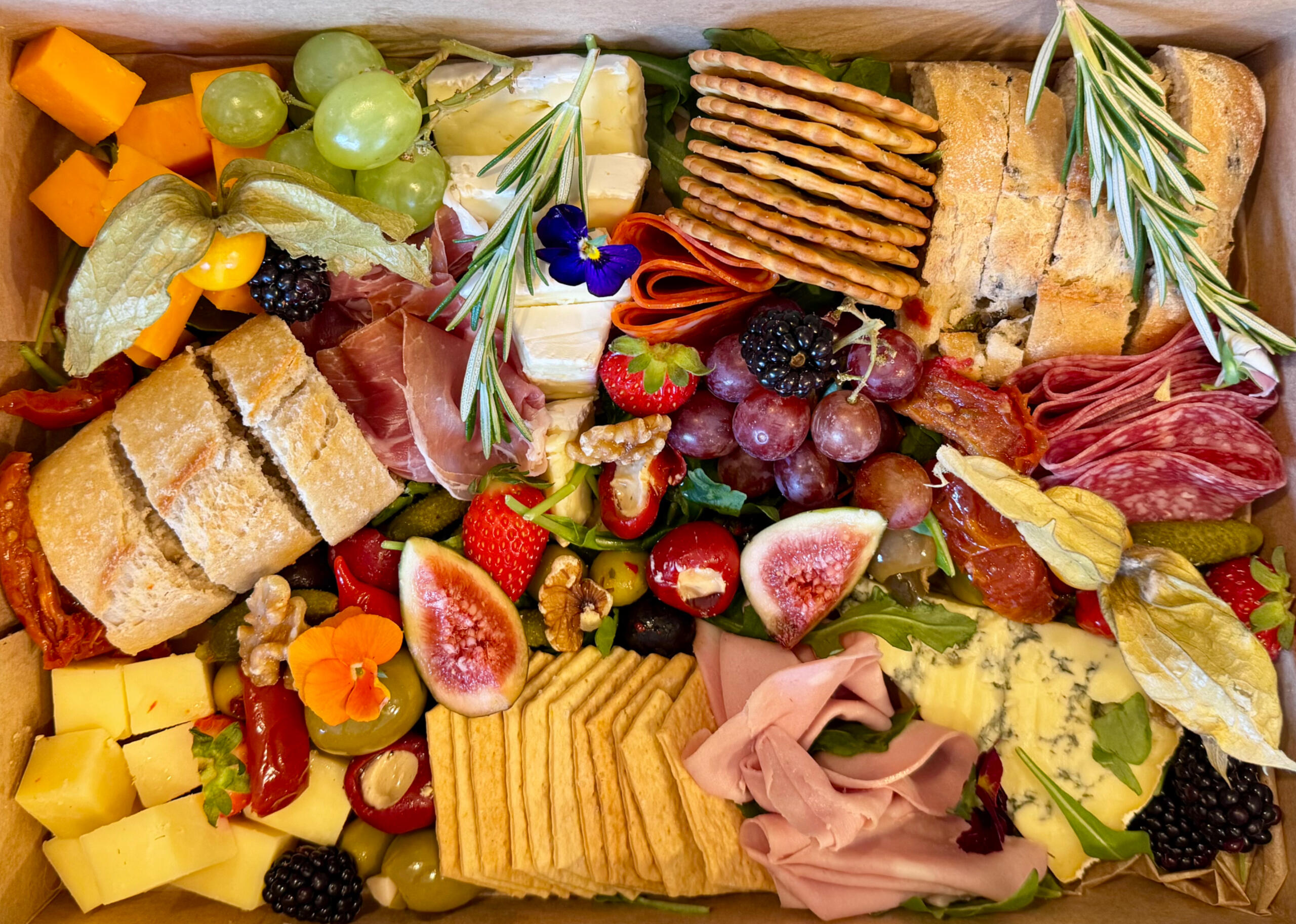 selection box of cheeses, meats, fruits and charcuterie